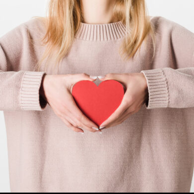 A woman gently holds a heart in her hands, symbolizing compassion, vulnerability, and the need for healthy emotional boundaries.